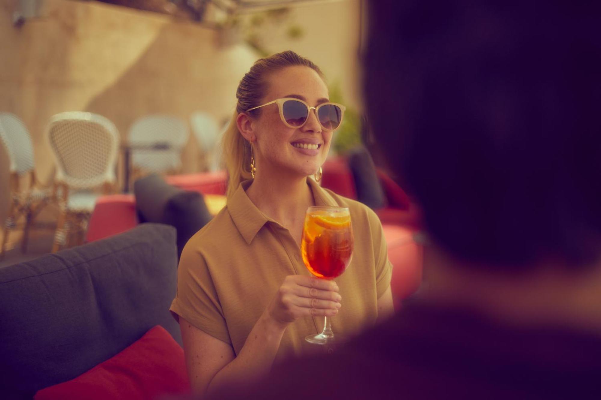 Secrets Mallorca Villamil Resort & Spa - Adults Only Peguera Exterior foto A woman drinking an Aperol Spritz
